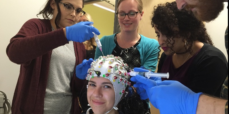 Dr. Lorna Quandt (center standing) performing an EEG demo experiment with Gallaudet University PhD in Educational Neuroscience students.