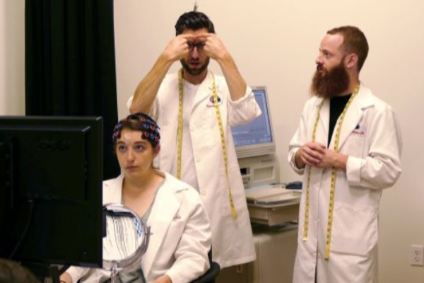 Three students in white lab coat and discussing together.