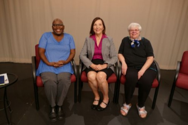 Three women sitting on panel together. 