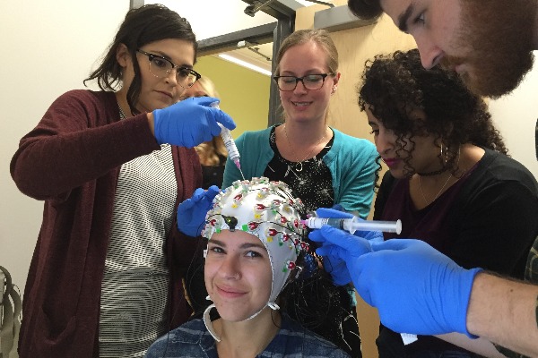 Dr. Lorna Quandt (center standing) performing an EEG demo experiment with Gallaudet University PhD in Educational Neuroscience students.
