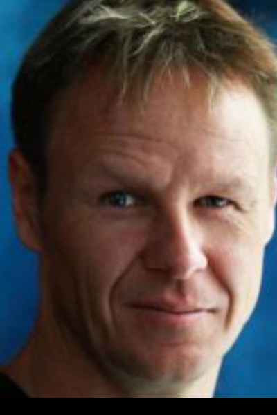 A headshot of a white man with short, blond hair. He has a neutral facial expression.