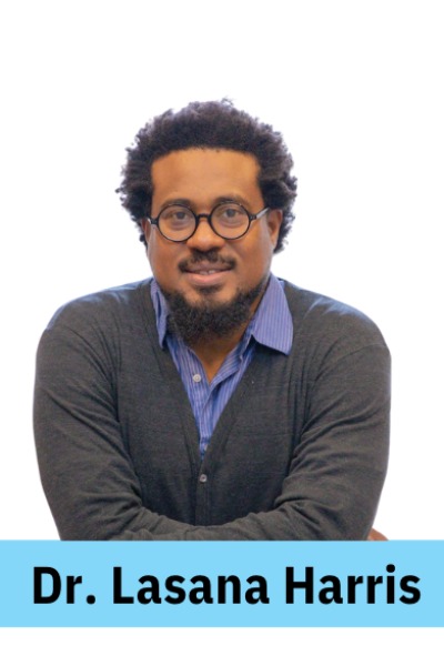 ID: A black-presenting man with short brown curly hair and round black glasses is smiling.